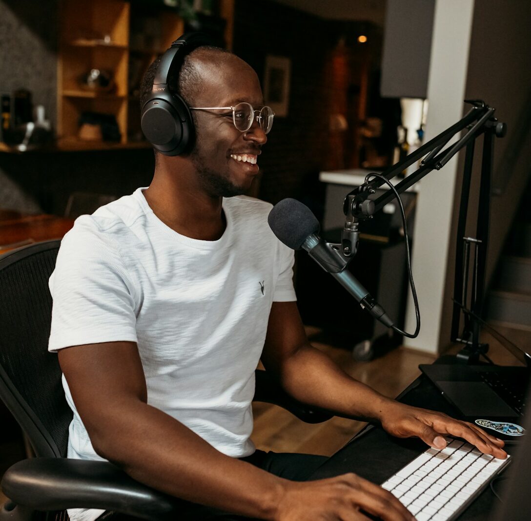 man in white crew neck t-shirt sitting on black office rolling chair