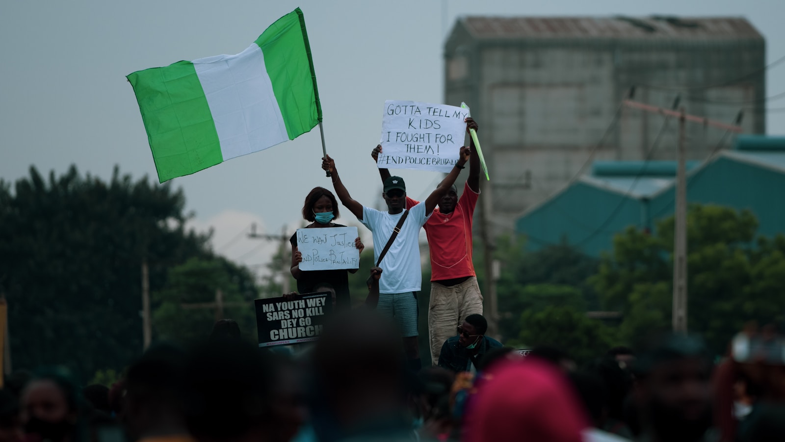 man in white shirt holding green flag